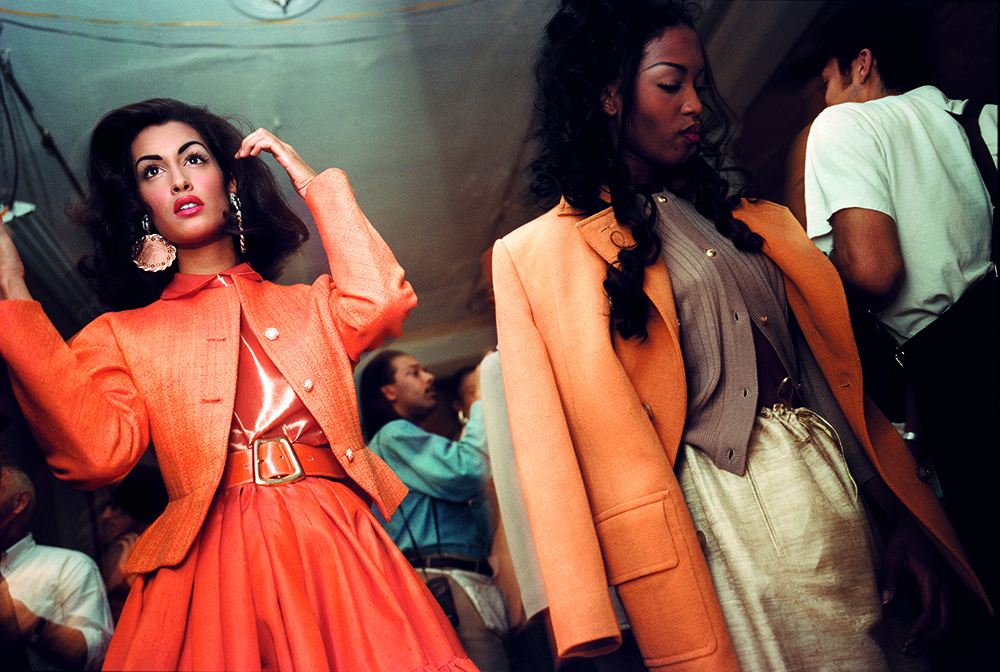isaac mizrahi fashion, two models backstage in oranges jackets
