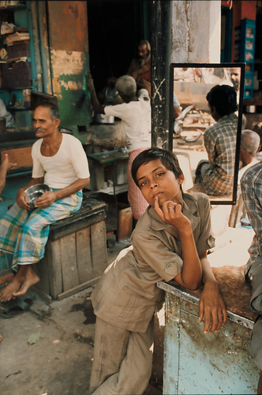 Indian Photographer Raghubir Singh photograph of a young boy who is an assistant of a betel leaf seller in Behares, India in 1987