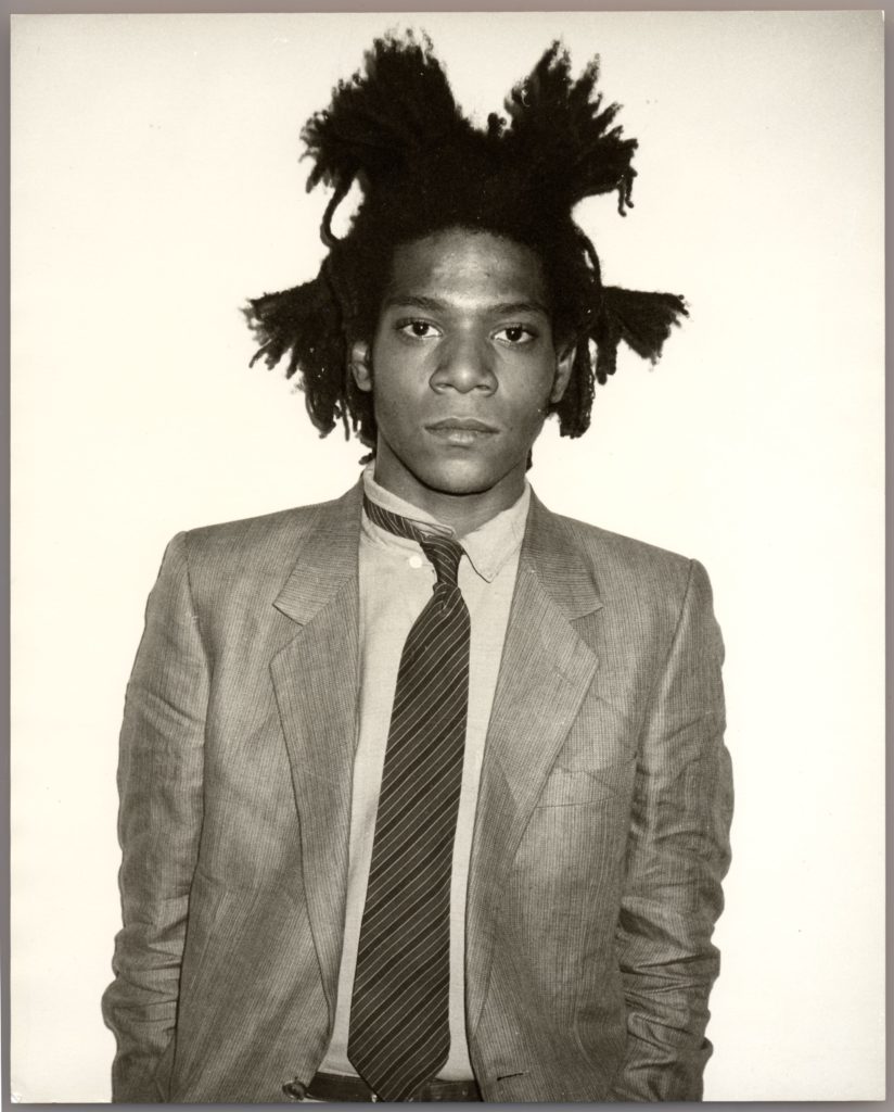 Artist Jean Michel Basquiat wearing a ruffled suit and tie
