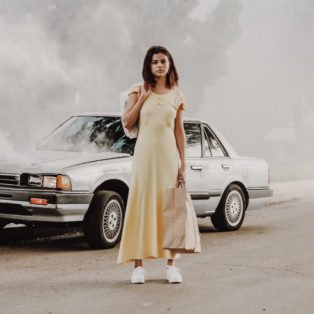 Petra Collins long yellow dress broken down car