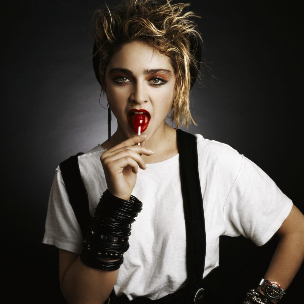 Photograph of Madonna in the 1980's sucking a lollipop and wearing black rubber bangles