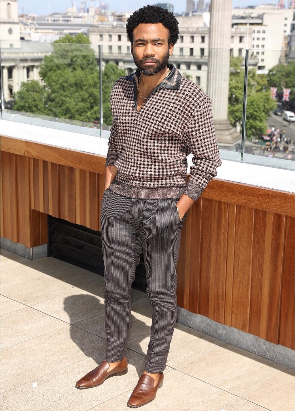 houndstooth knit sweater with a leather-trimmed collar mixed with tweed and stripped trousers accessorized with his signature loafers and no socks.