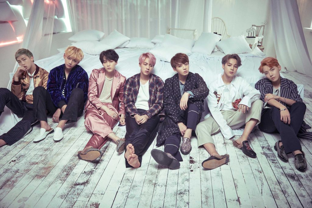 BTS on floor in front of bed