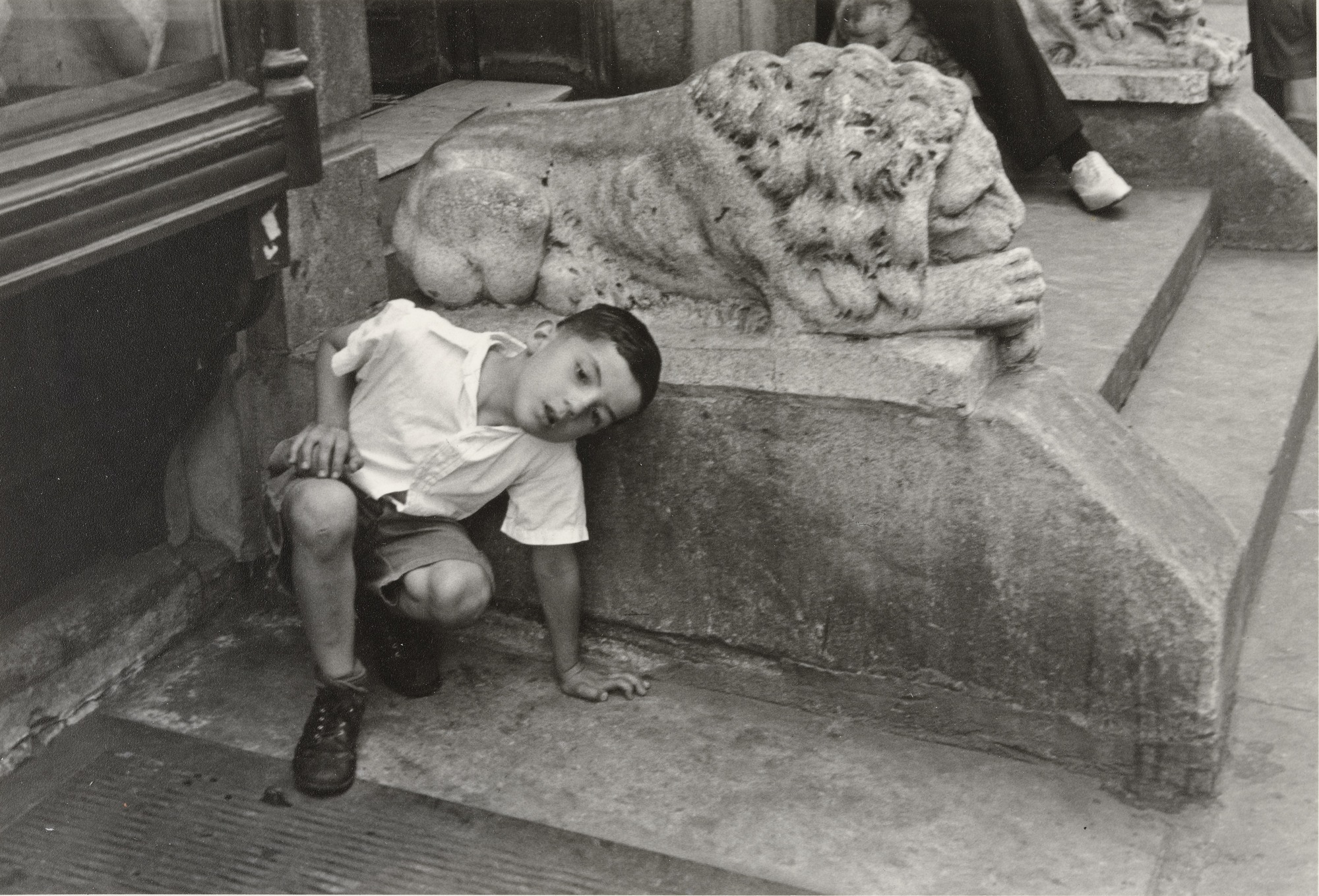 Boy playing game in front of stairs, by Helen Levitt