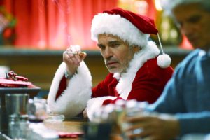 Billy Bob Thornton as Bad Santa sitting at a bar smoking a cigarette
