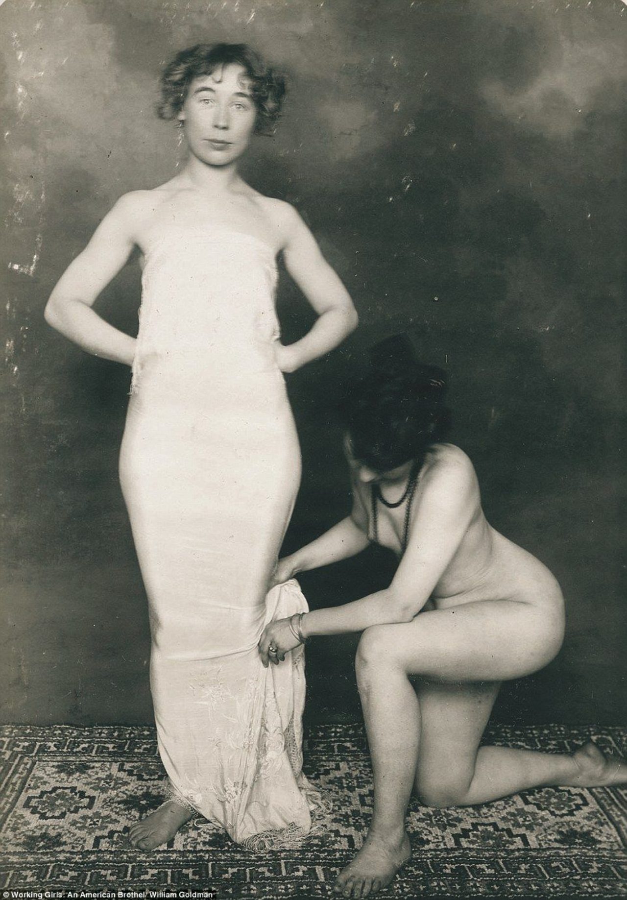 antique photo of a nude woman tailoring the hem of another woman's skirt, 1892