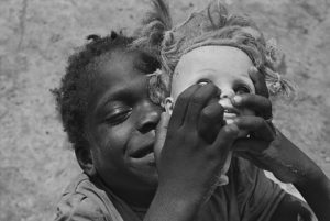 Photograph of an African boy holding a dolls head shot by Eugene Richards