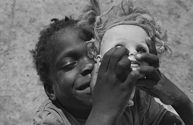 Photograph of an African boy holding a dolls head shot by Eugene Richards
