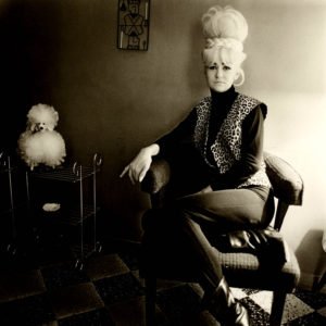 diane-arbus-image-of-a-woman-with-a-blonde-bouffant-leoparrd-vest-next-to-a-poodle