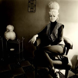 diane-arbus-image-of-a-woman-with-a-blonde-bouffant-leoparrd-vest-next-to-a-poodle