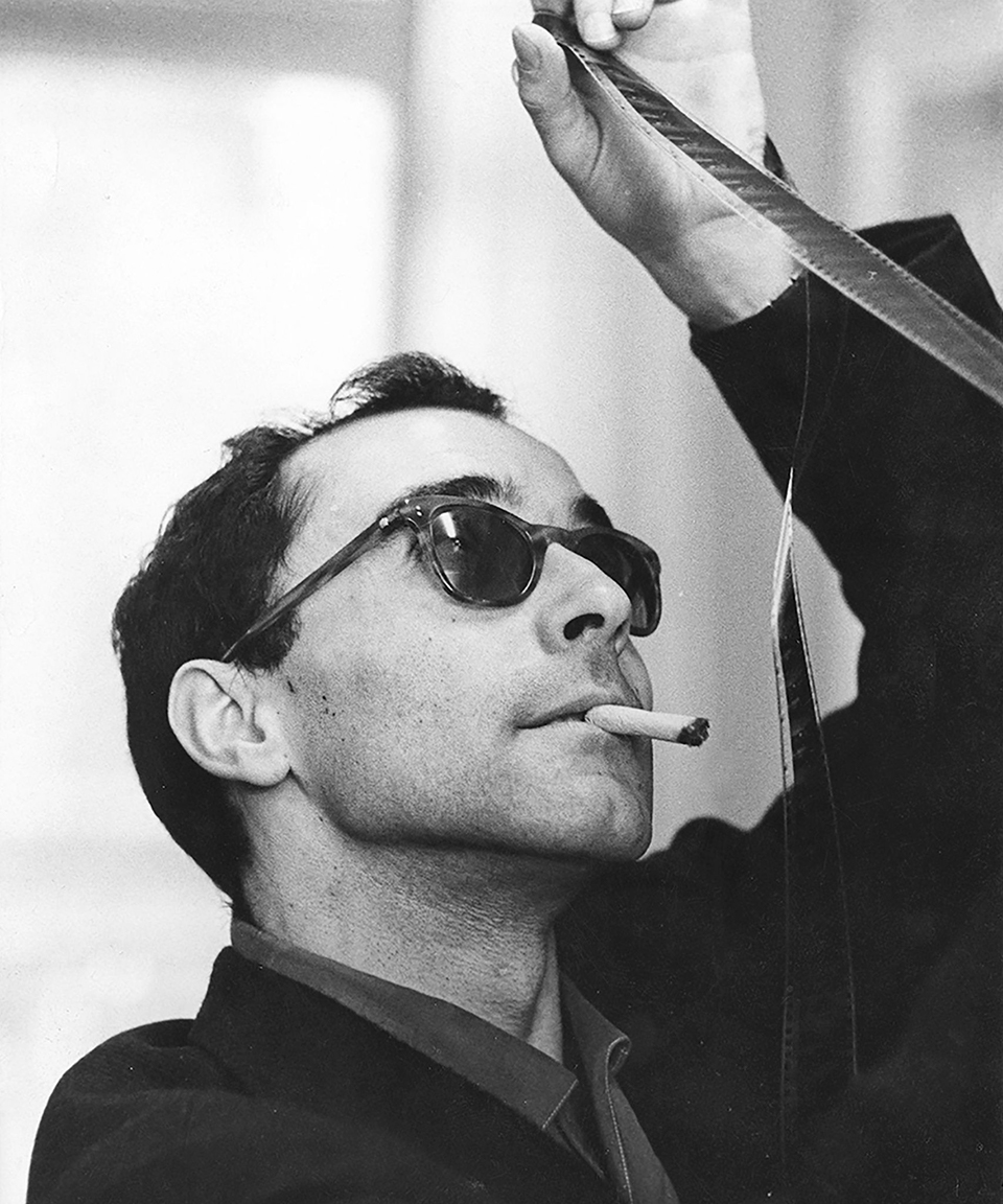 Jean Luc Godard looking at film negatives