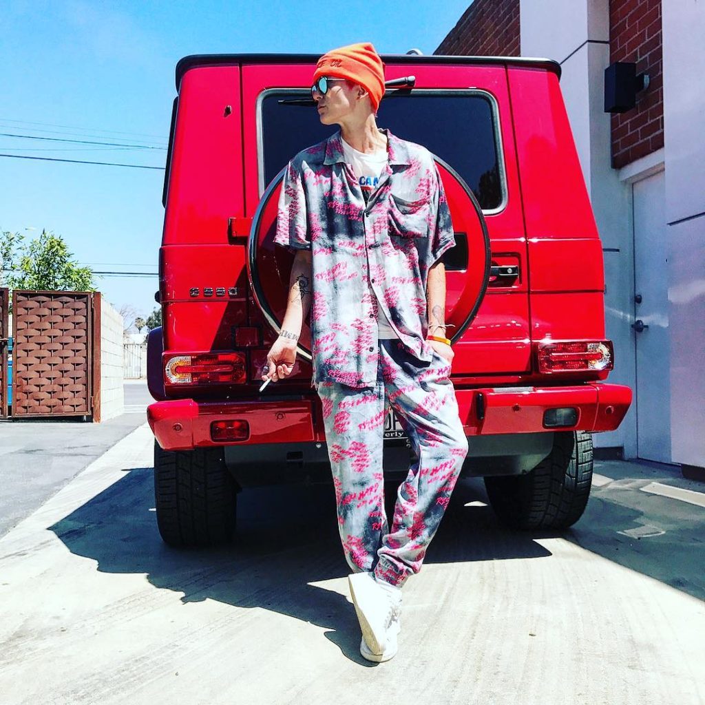 Nats Getty Wearing Hand Painted Pajama Set In Front of Her Red MBZ Land Cruiser