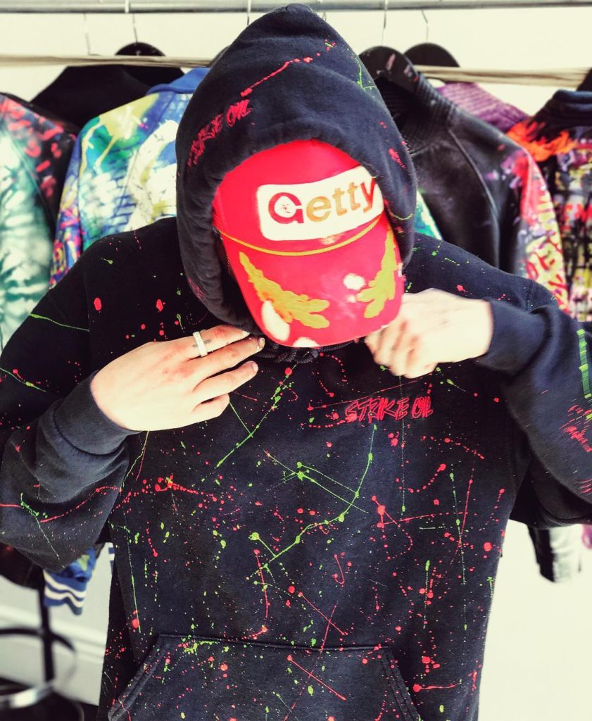 Nats Getty Wearing a Getty Baseball Cap and Black Spray Painted Hoodie