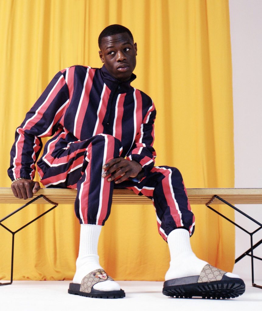 j-hus-wearing-asos-blue-red-and-white-striped-jacket-and-pants-white-crew-socks-and-slides
