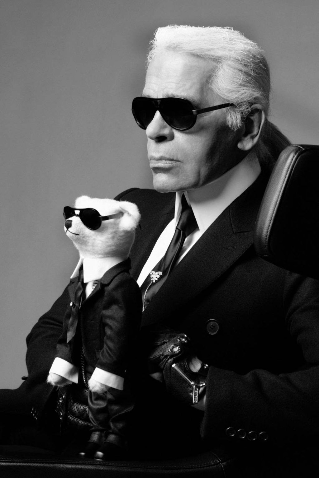 Photograph of Karl Lagerfeld Holding a Teddy Bear Wearing Matching Clothes and Sunglasses