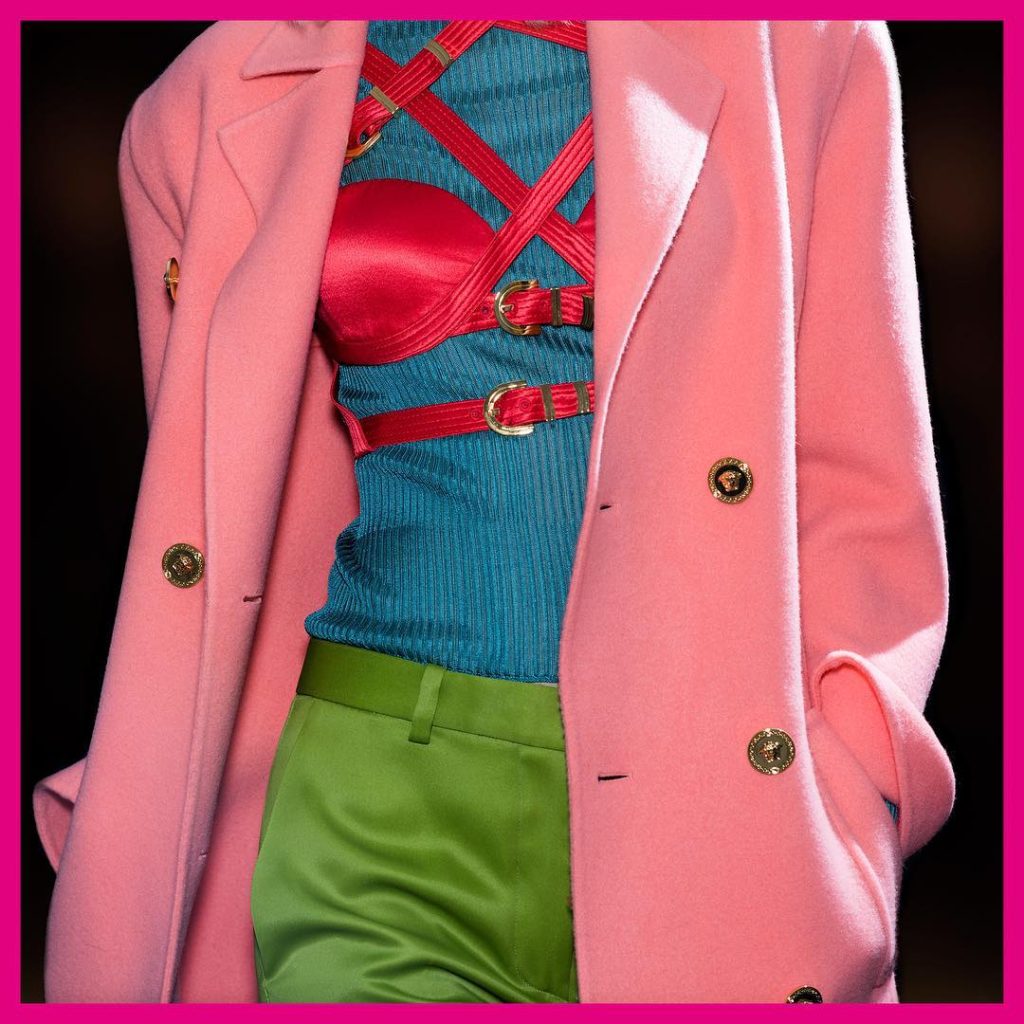 Versace Fall 2019 Runway Look-Pink Jacket with gold buttons, Pink Bondage Bra, Blue Sweater and Lime Green Pants
