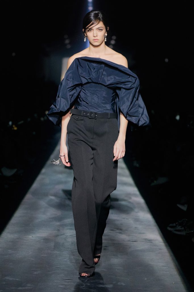 GIVENCHY 2019 FALL COLLECTION RUNWAY SHOW-FEMALE MODEL WEARING A ASYMETRICAL NAVY TOP AND BLACK PANTS