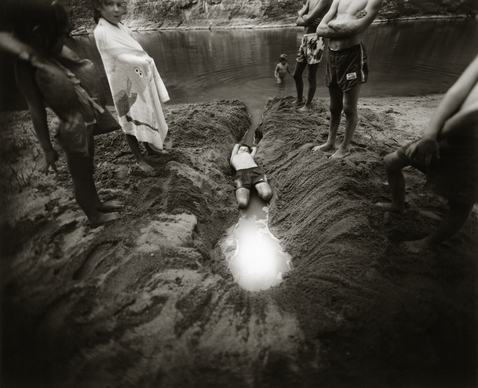 sally mann photograph of young boys playing in the dirt near a river