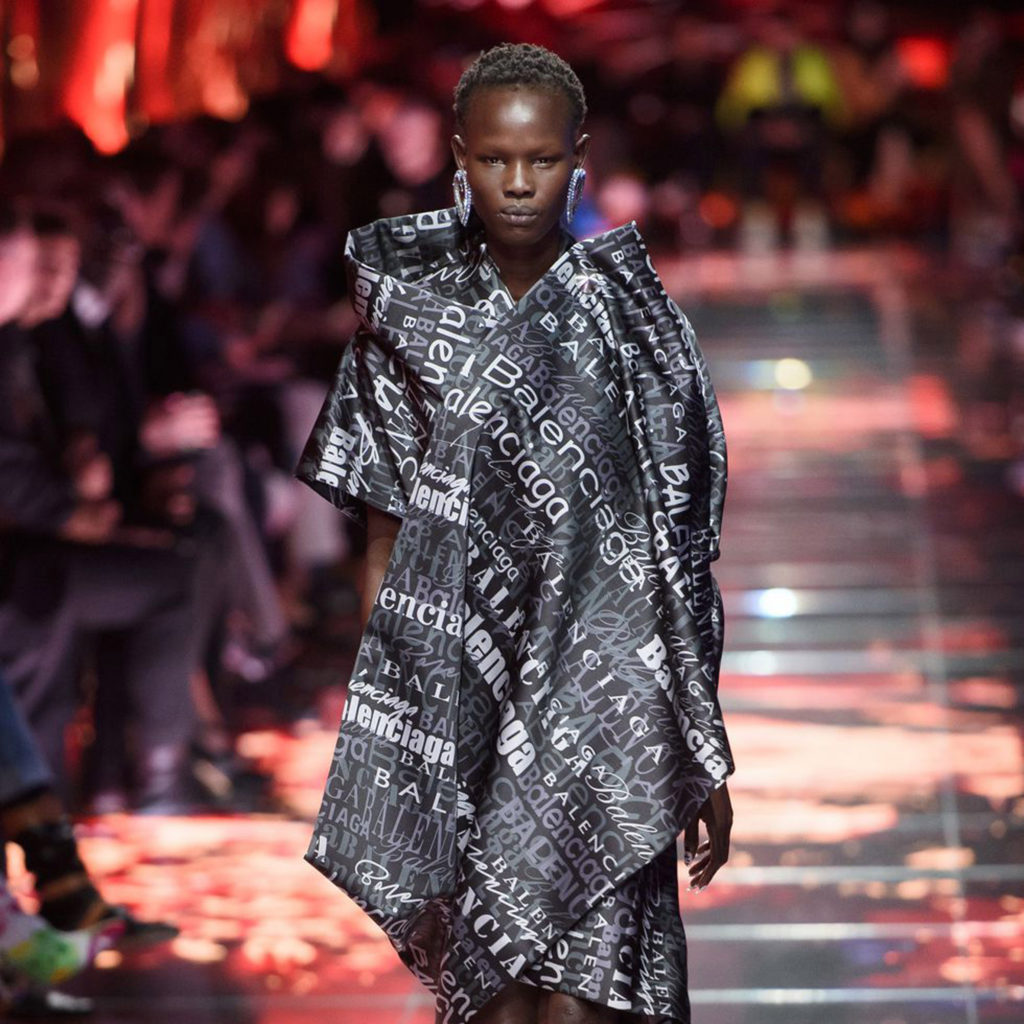 balenciaga-spring-summer-2019-runway model wearing caftan with Balenciaga printed all over-paris_dezeen_sq1