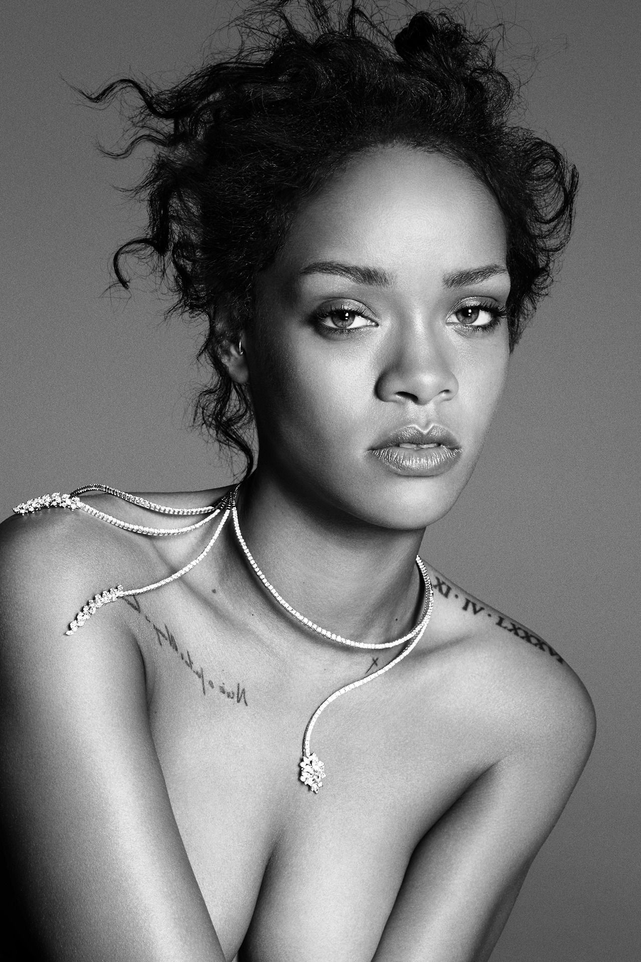 Rihanna photographed topless wearing an ornate necklace