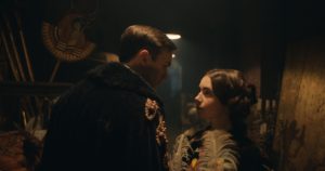 nicholas hoult-lily collins holding a feather on the film set of Tolkien