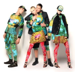 versace-collaboration-with-HM-2011-campaign image of 4 models wearing head to toe Versace H&M outfits in pink and green