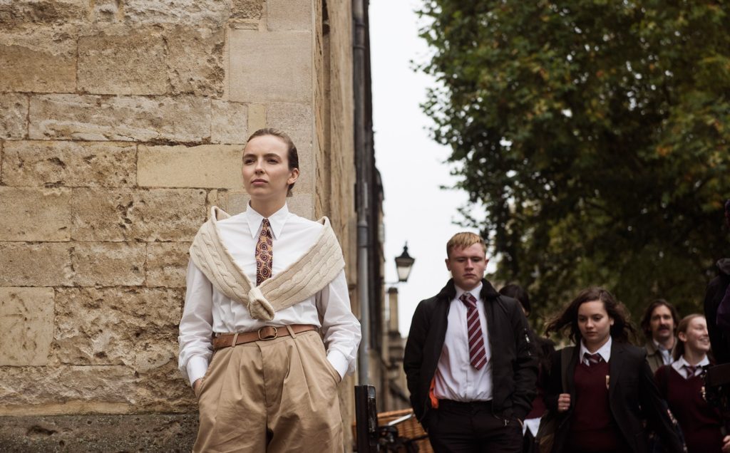 Vilanelle in Kllling Eve Wearing Prep School Tie, White Shirt, Beige Cable Knit Sweater and Khakis