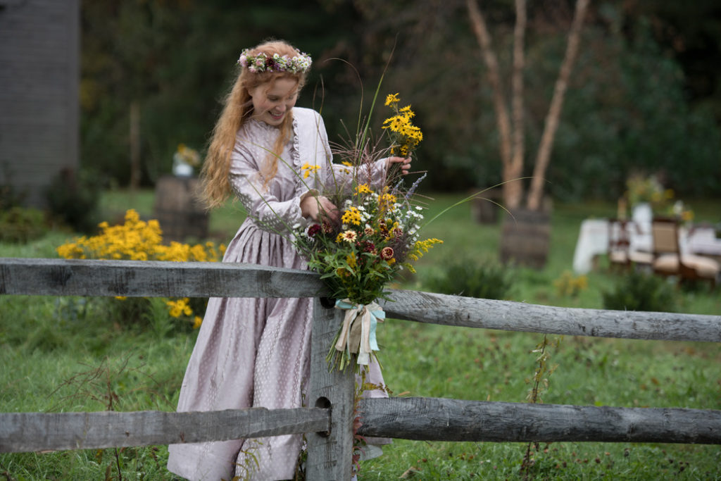 Eliza Scanlen as Beth March in Little Women Holding a bunch of wild flowers and wearing floral wreath