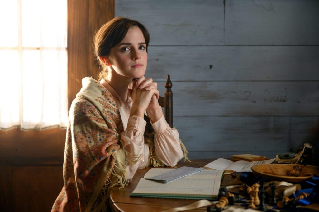 Emma Watson in Little Women sitting at the kitchen table wearing a beautiful shawl
