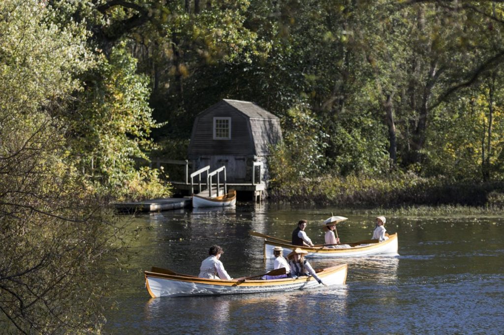Little Women scene of the March sisters and Laurie in white wooden row boats on a lake