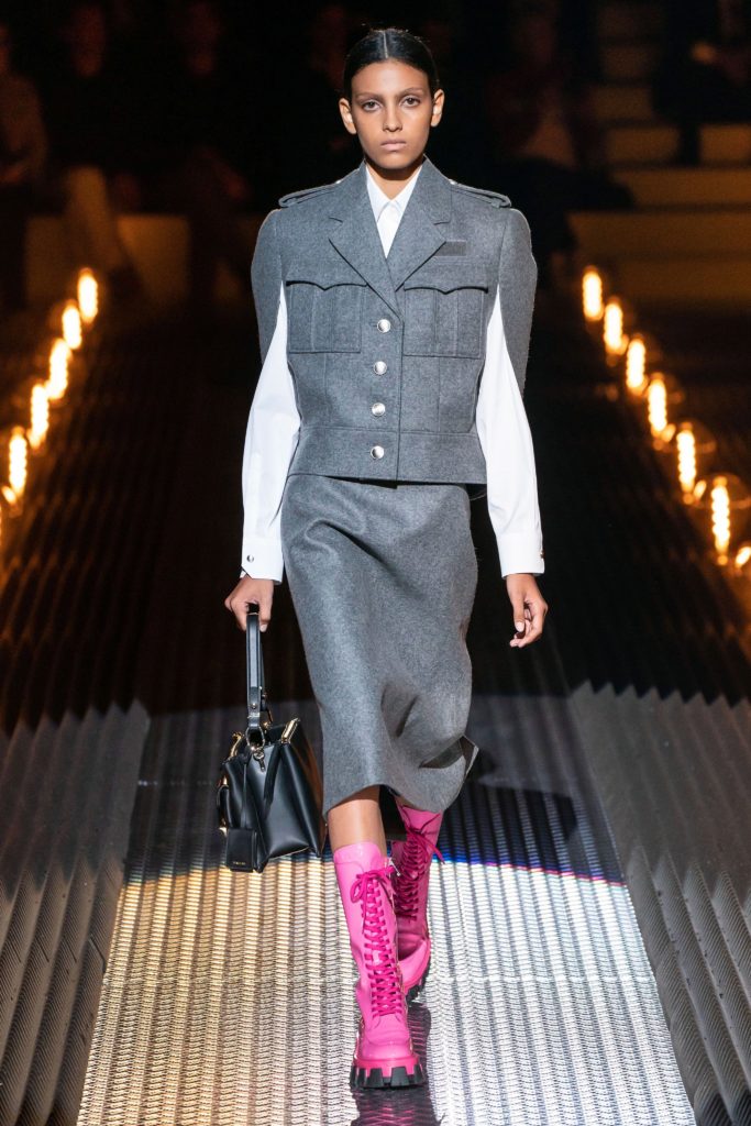 PRADA Runway 2019 Model Wearing Gray Military Inspired Jacket and Skirt and Hot Pink Lace Up Boots