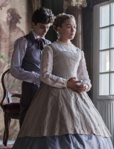 Timothee Chalamet as Laurie and Florence Pugh as Amy Marsh in a scene where Laurie is tying the back of Amys dress