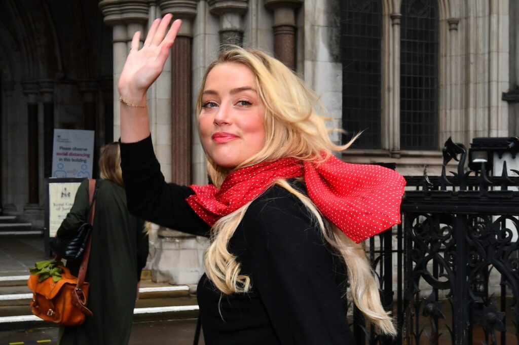 Amber Heard arriving at court in London waving to supporters