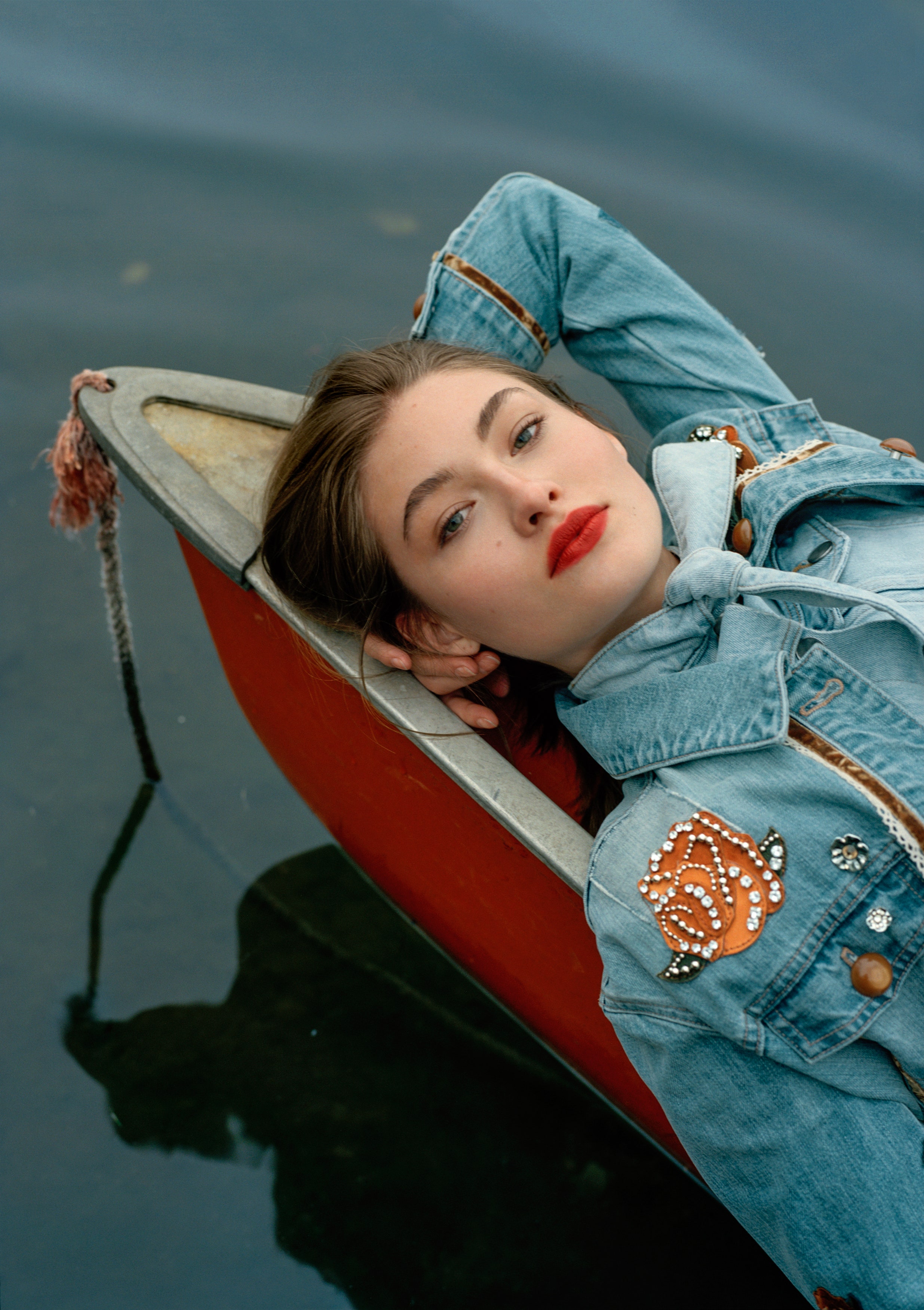Model-Grace-Elizabeth-Laying-on-A-Red-Canoe-Wearing-a-Jewel-Embellished-Jean-Jacket