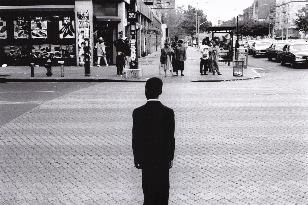 CHURCH BOY: A boy stands on the corner of 125th Street and Fredrick Boulevard a moment before he crossed on his way to church at the United House of Prayer for All People, June 1994 Shot By Ozier Mohammad