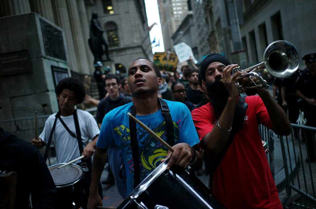 DRUMS AND TRUMPET ON WALL STREET: Members of the Occupy Wall Street Movement marched from Zucotti Park to the New York Stock Exchange at the end of the trading day, Sept. 2011 shot by Ozier Mohammad
