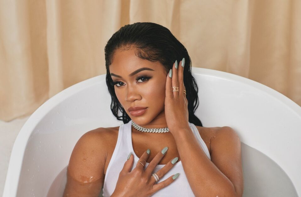 Saweetie full clothed in the bathtub