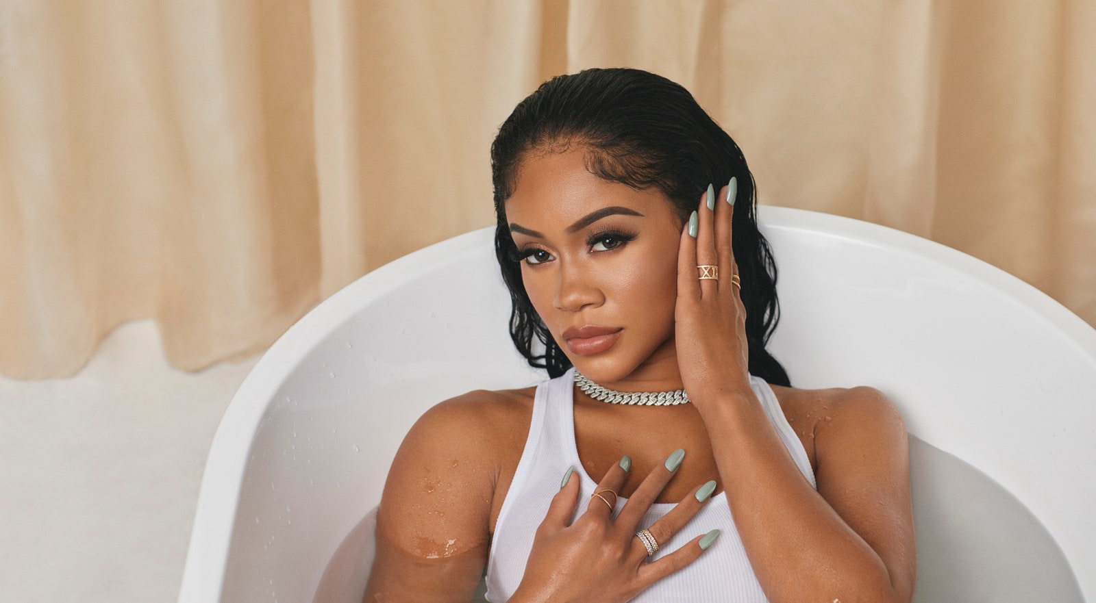 Saweetie full clothed in the bathtub
