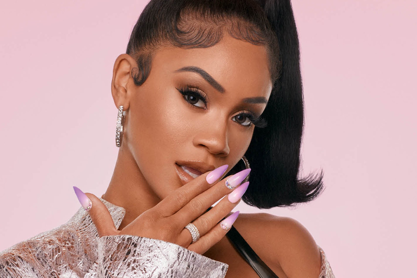 Saweetie with pink fingertips touching her mouth