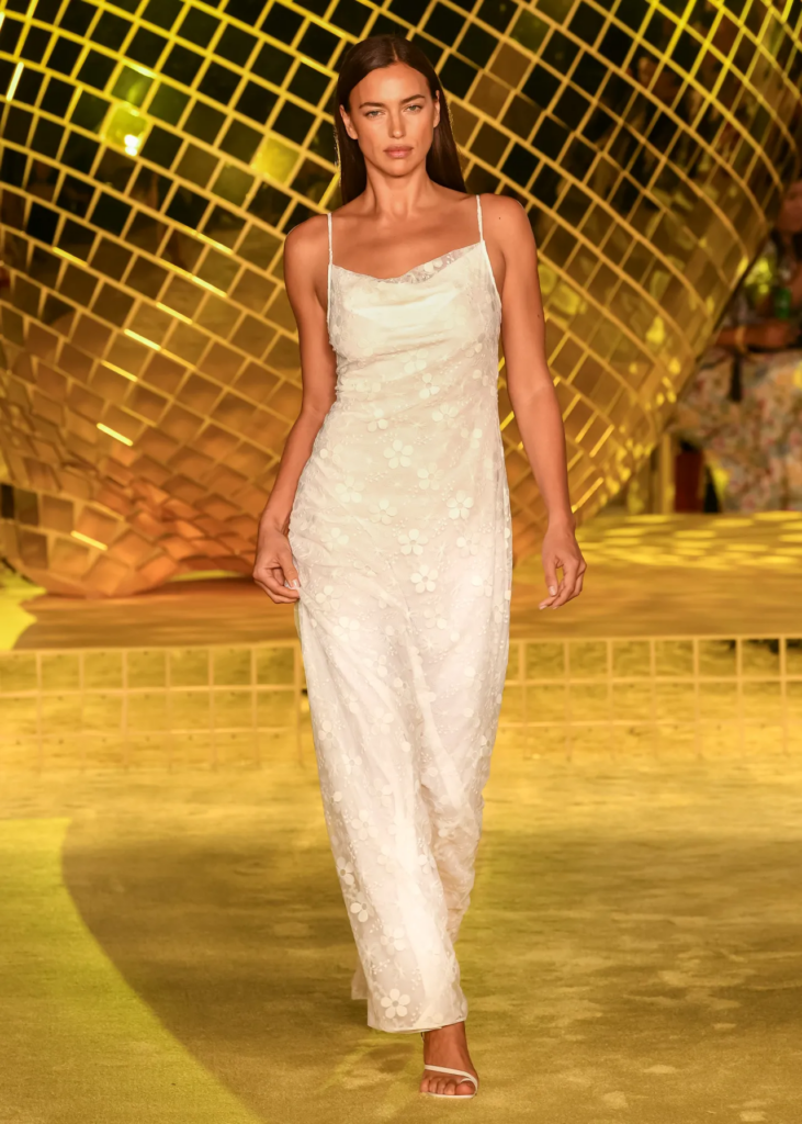 Staud Spring Summer 2022 Runway Model in Long White Dress In front of Gold Disco Ball