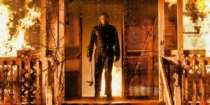 HALLOWEEN KILLS EVIL MAN IN THE DOOR FRAME OF A HOUSE ON FIRE WITH AN AX