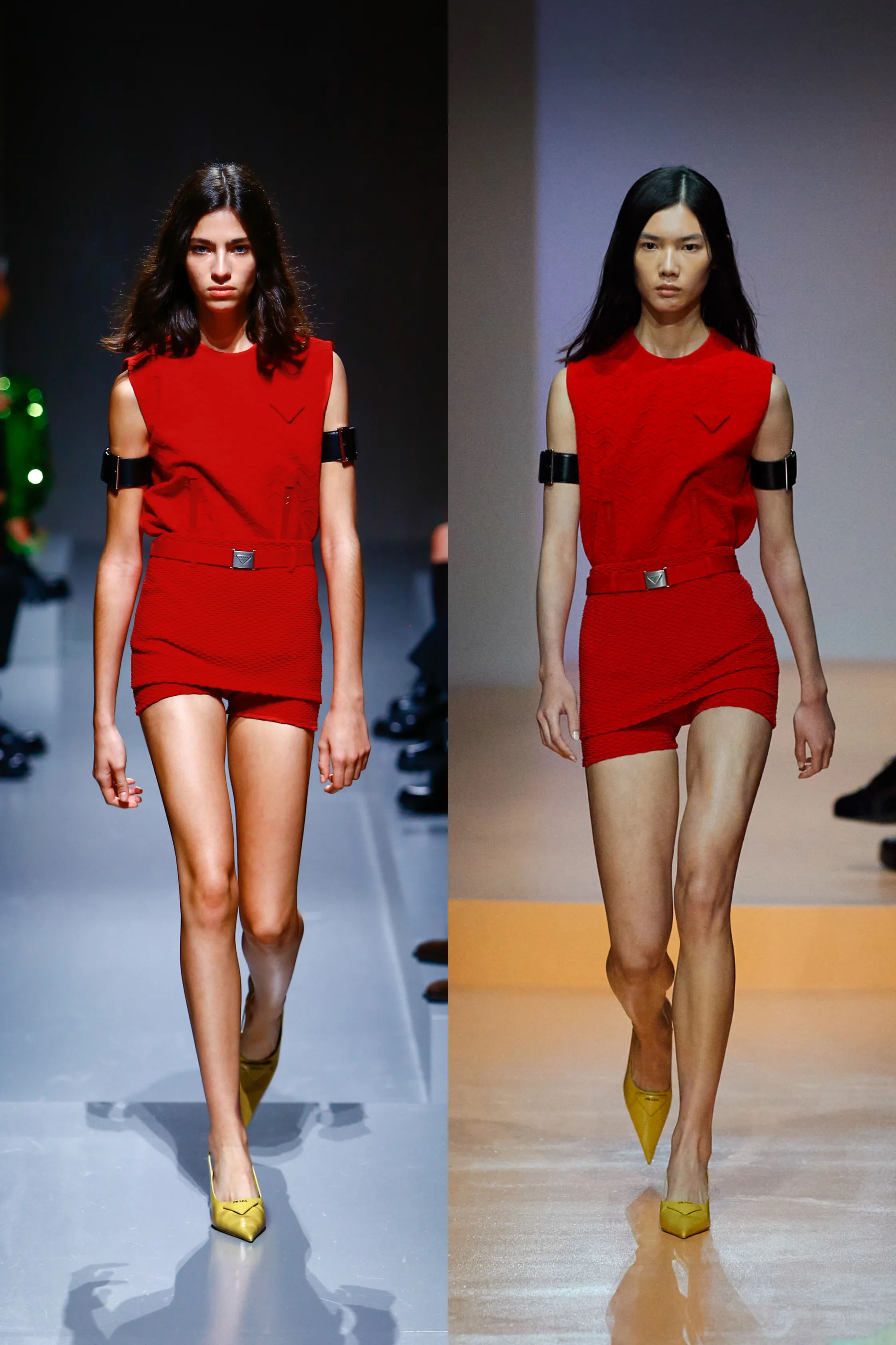 PRADA RUNWAY SPRING SUMMER 2020 MODELS SIDE BY SIDE WEARING RED HOT PANTS, RED SLEEVELESS TOPS AND BLACK BUCKLE ARM BAND