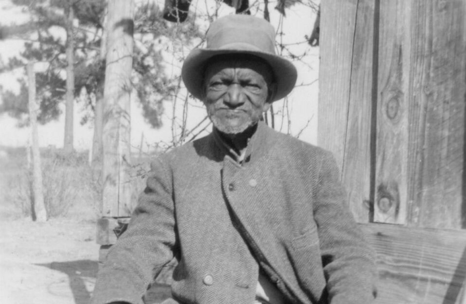 West Brady Ex Slave Sitting In front of his Slave Cabin