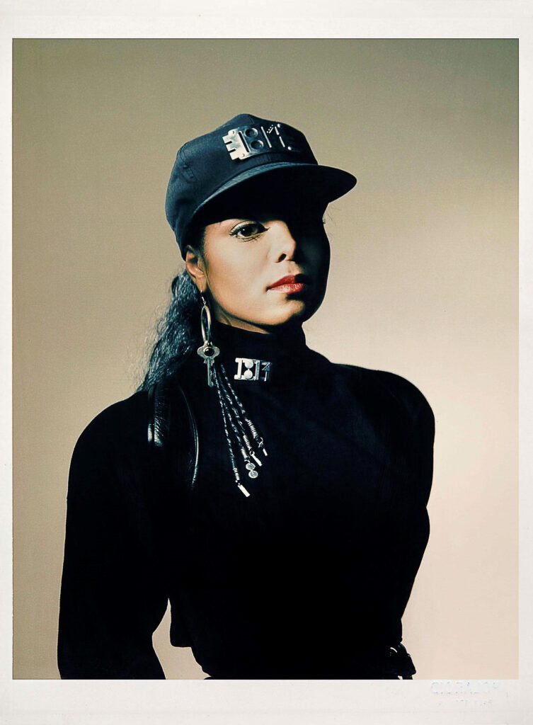 Janet Jackson with Black Cap and a cool long earing with a key