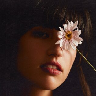 Rozzi holding a flower covering her left eye