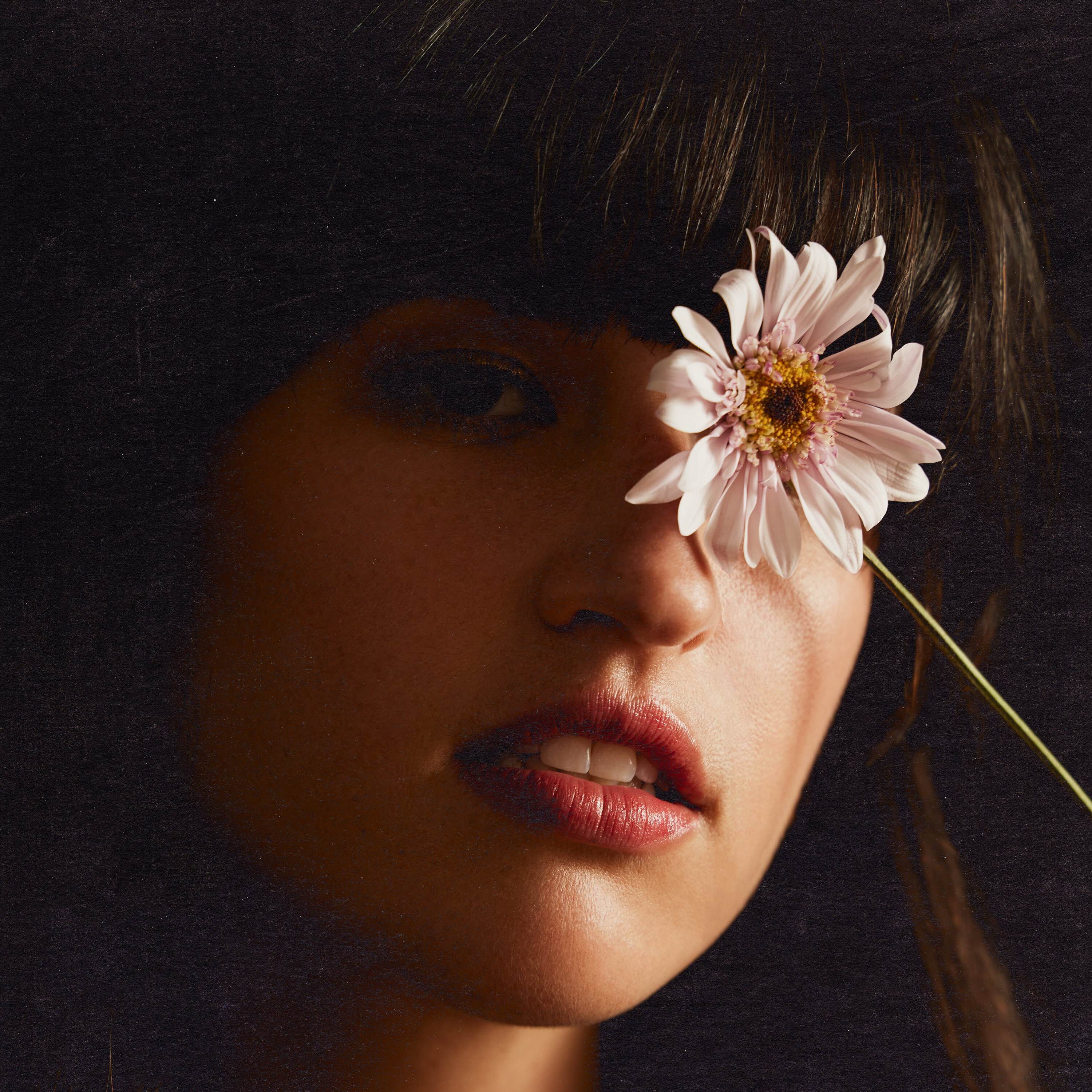 Rozzi holding a flower covering her left eye