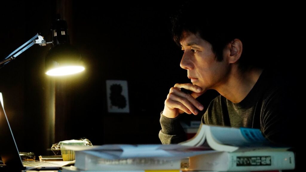 Drive My Car Yūsuke Sitting at His Office Desk