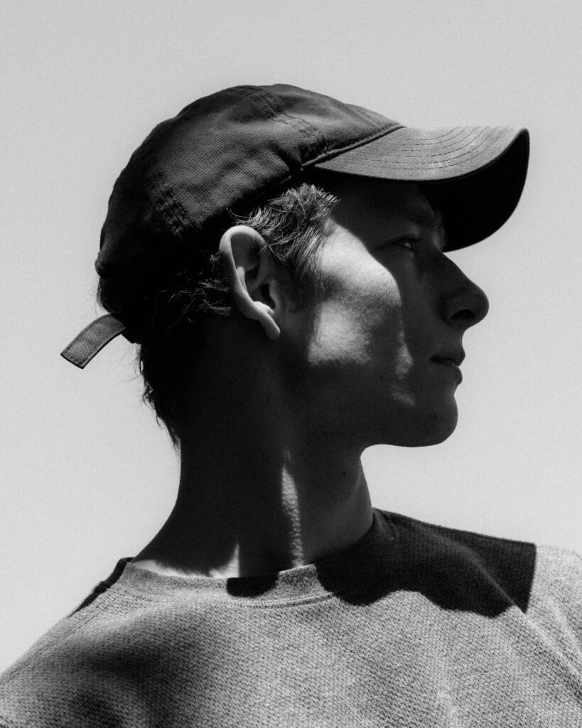 Mike Faist in a baseball cap right side profile