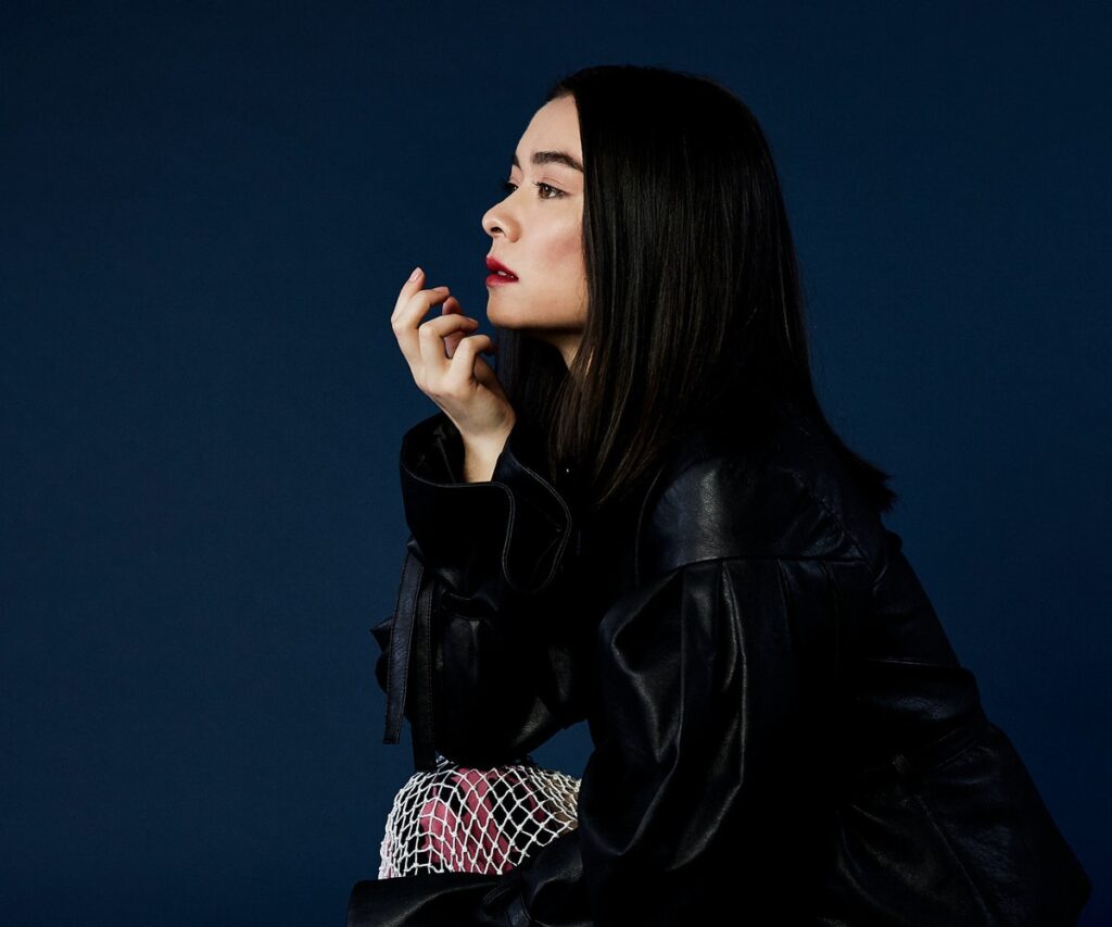 Mitski Left Side Profile And Wearing Black Leather Top